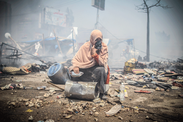 A protester sits amid rubble during the clearing of one of two pro-Morsi sit-ins, near the Rabaa al-Adawiya mosque, August 14, 2013 © Mosa’ab Elshamy/Getty Images 