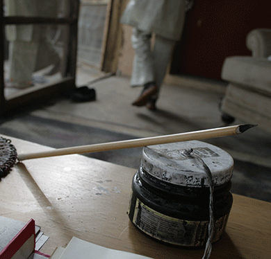 Ink and pen next to an unbound Koran at a house in Kano © Caelainn Hogan