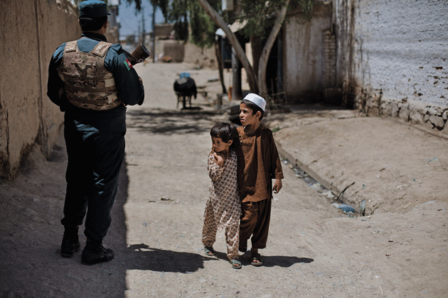 A brother and sister walk past a checkpoint in Subdistrict 2, April 27, 2014. 