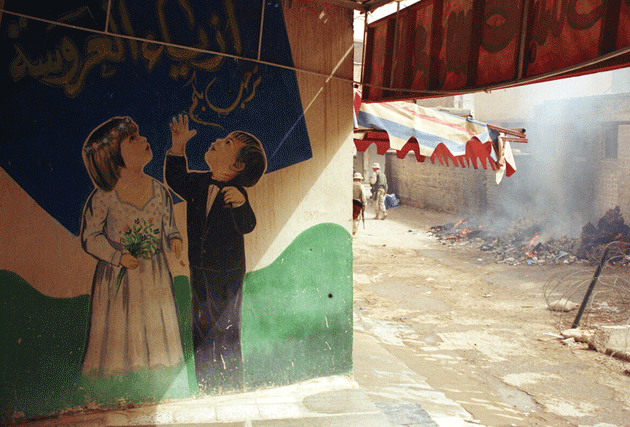 A Marine patrol passes a wedding-supply store in the Kut souk, 2003. All photographs by the author