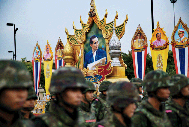 Soldiers stand near posters of King Bhumibol Adulyadej during a demonstration against the recent military coup, at the Victory Monument in Bangkok, May 26, 2014 © Adam Ferguson/New York Times/Redux