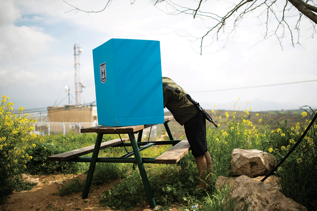 An Israeli soldier casts his ballot for the parliamentary election at a mobile voting booth in the West Bank Jewish settlement of Migdalim, March 17, 2015 © Reuters/Amir Cohen
