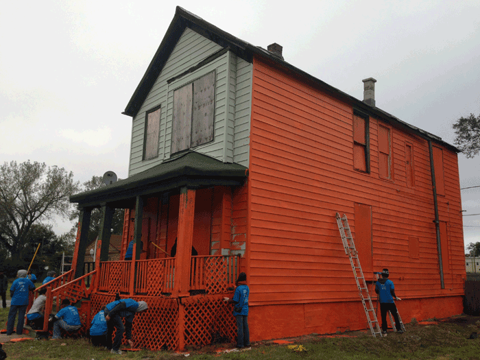 Volunteers painting one of the eight houses in Amanda Williams's "Color(ed) Theory" series.