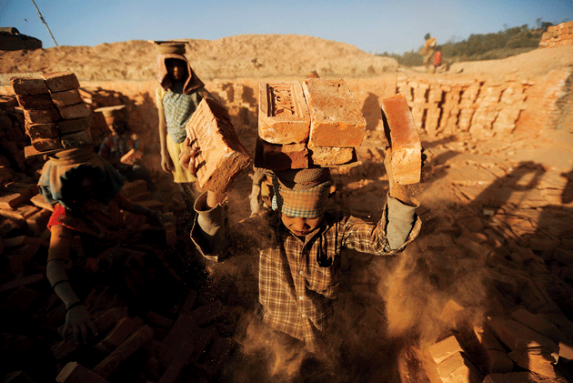 Child laborers from India and Nepal load bricks onto their heads at a factory in Lalitpur, Nepal, February 10, 2014 © Narendra Shrestha/EPA/Newscom
