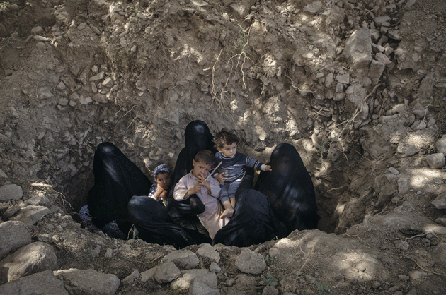 Women and children who were displaced from their village by air strikes seek shelter in the ground near Fella, in Saada governorate, where a local school housed them. When the women hear warplanes or antiaircraft fire, they feel safer in the ground. Photograph by Maria Turchenkova