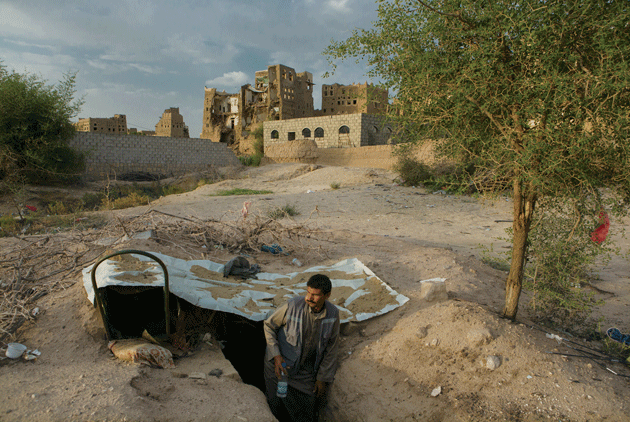 A man stands in a shelter dug into the ground in Rahban, on the outskirts of Saada city. Much of Rahban was destroyed by a series of air strikes in March 2015. Photograph by Maria Turchenkova