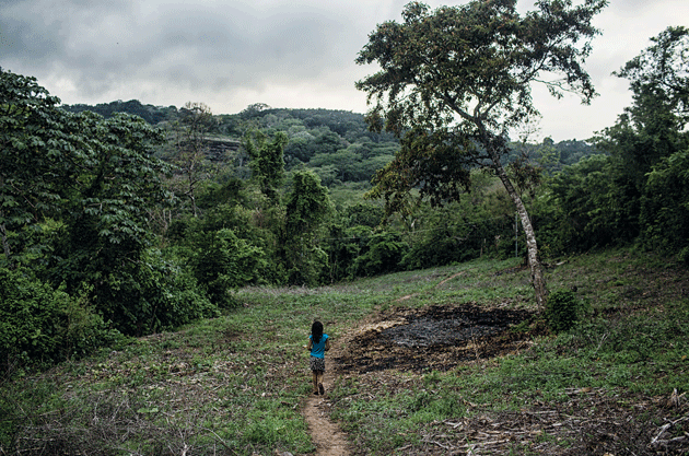 María de los Ángeles walks along the path on which her family carried Flor after she prematurely gave birth, San Julián, Sonsonate