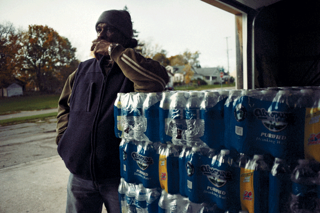 Deacon Darris Berry of Shiloh Missionary Baptist Church waits for Flint residents to collect water that they will use in their homes