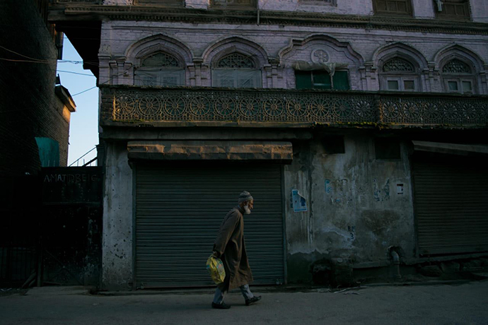 A Kashmiri man walks by on an empty road during the city’s shutdown. (R. Latif)