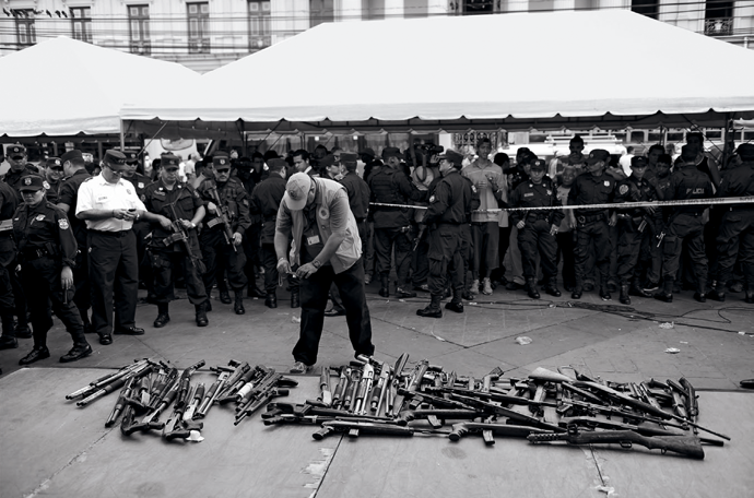 An OAS delegate inspects guns at Gerardo Barrios Square, where alleged gang members handed over weapons as part of a partial disarmament agreement, San Salvador, July 12, 2012 © Jose Cabezas/AFP/Getty Images