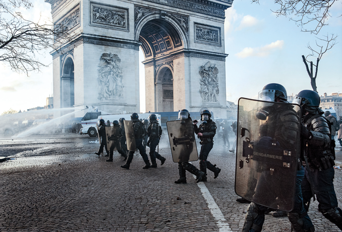 Police officers disperse protesters with a water cannon, March 16, 2019