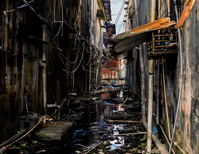An alleyway flooded due to a broken public water spout. Water service is irregular in Colón, where residents bathe and gather water for cooking at public spigots.