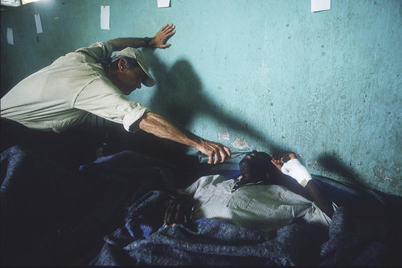 Photographer James Nachtwey offers water to a man in Rwanda, 1994 © Scott Peterson/Liaison/ Getty Images