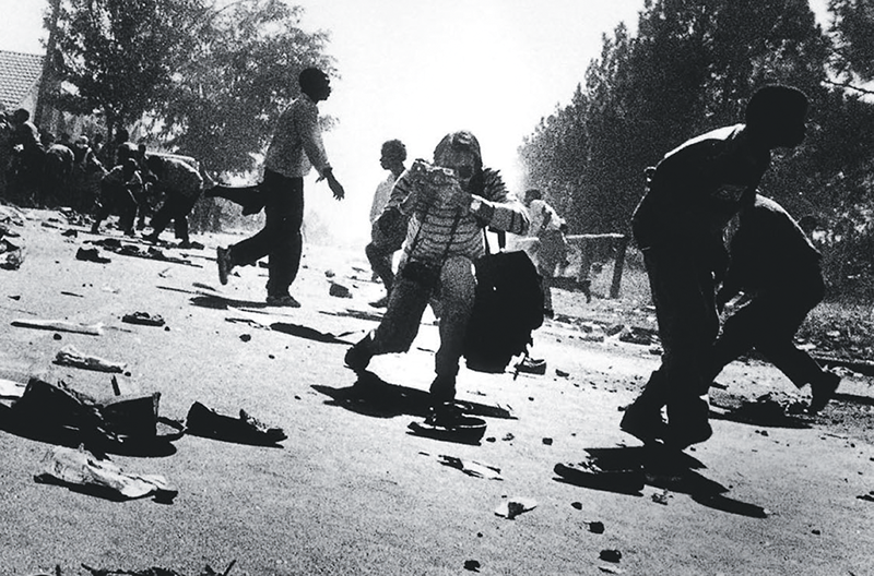 Kevin Carter photographing police firing on a protest in Soweto, Johannesburg, 1993 © Ken Oosterbroek. Courtesy Monica Zwolsman