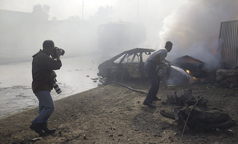 João Silva, a member of the Bang Bang Club, photographing a car bombing in Baghdad, 2003 © Michael Kamber/New York Times/Redux