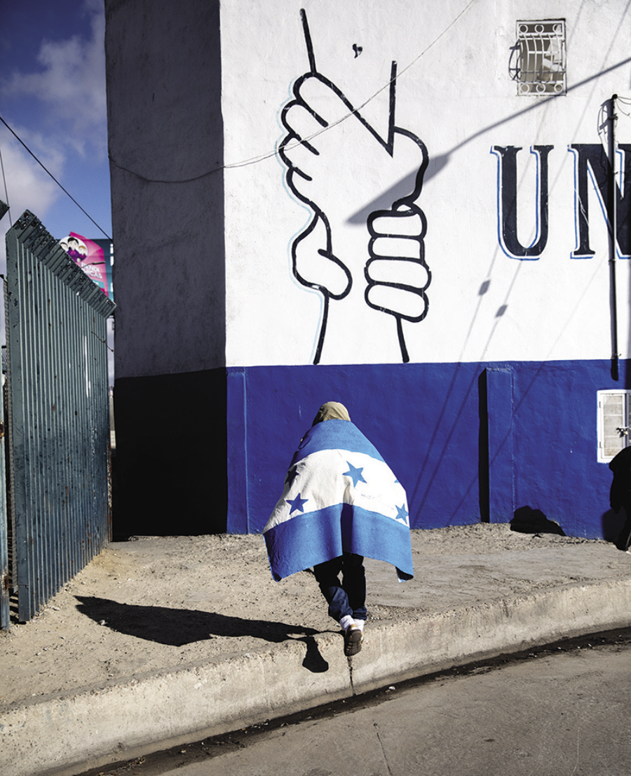 A migrant draped in a hand-painted Honduran flag in Tijuana, Mexico, December 2018 (detail). All photographs by Tomás Ayuso © The artist